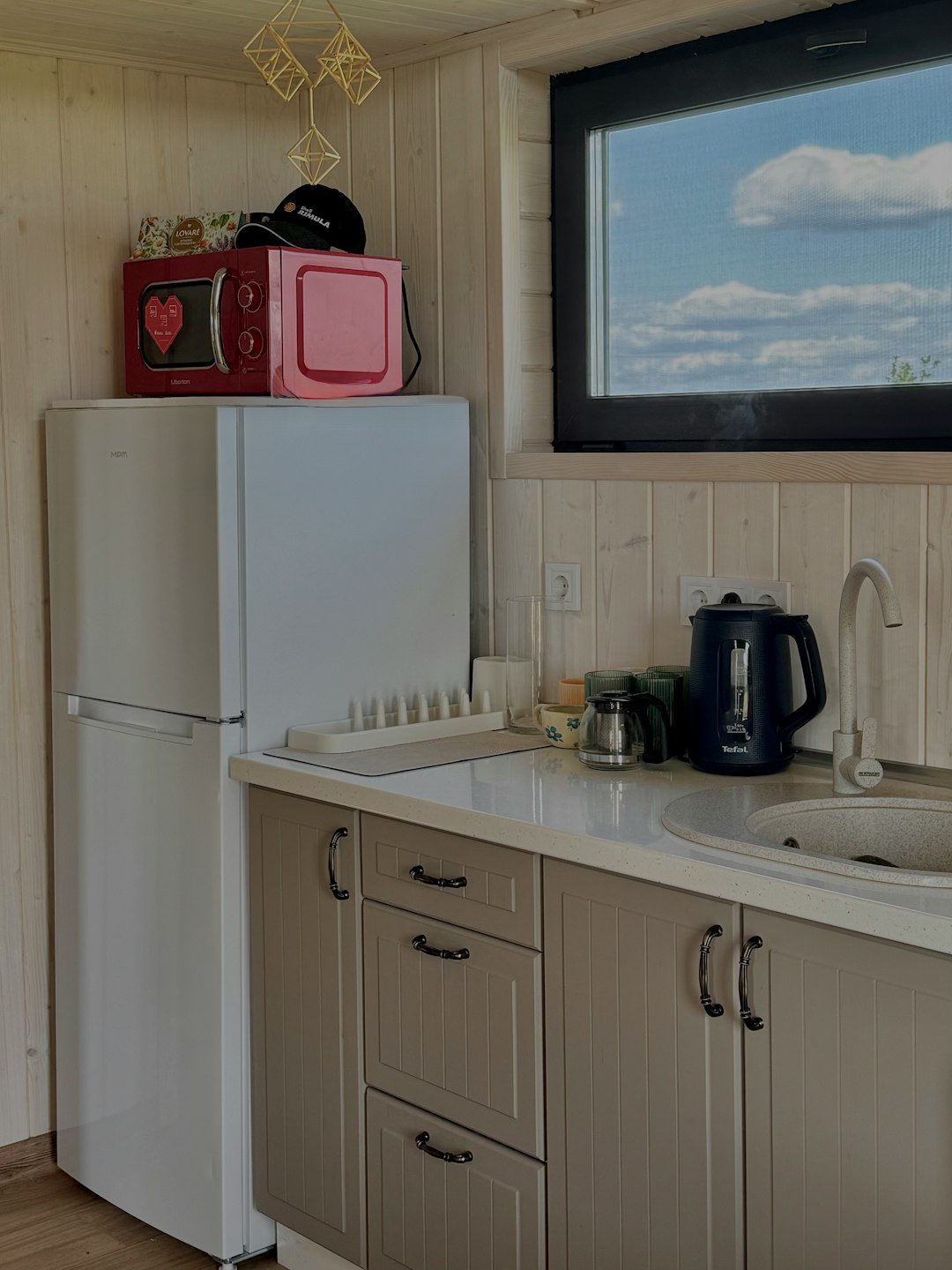 Compact kitchen with a small refrigerator, microwave and sink